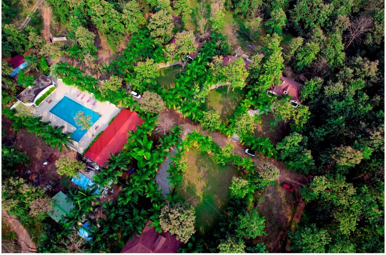 Rosewood Villas Pench aerial view of resort buildings and swimming pool set inside the forest.