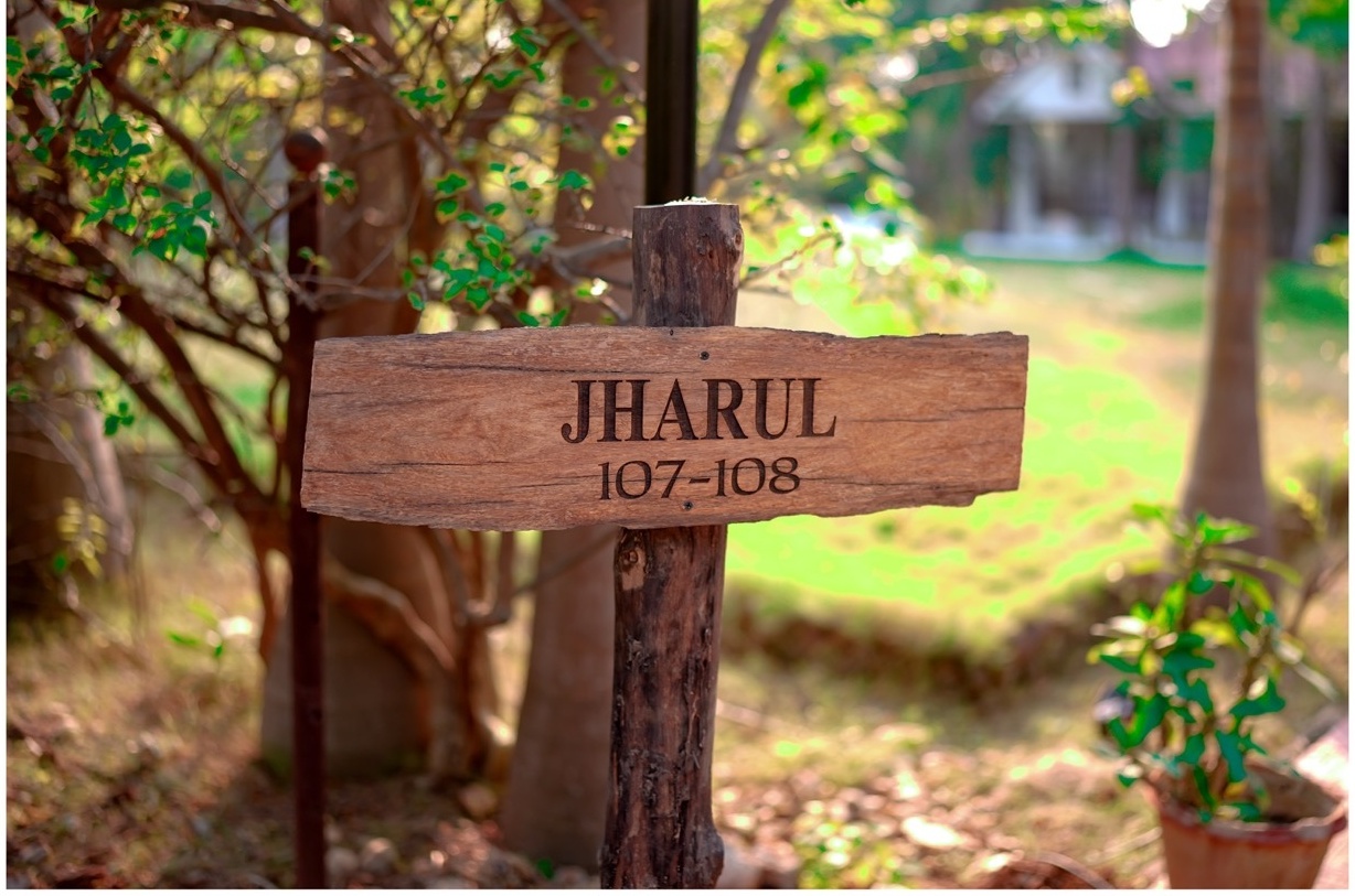 Rosewood Villas Pench Jharul villa wooden signboard placed in the garden walkway.