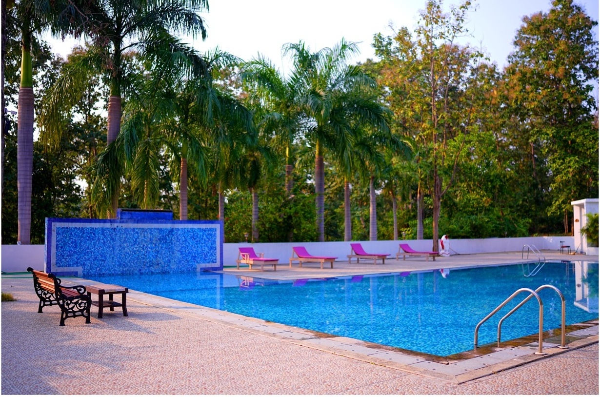 Rosewood Villas Pench poolside loungers facing waterfall feature wall at the swimming pool.