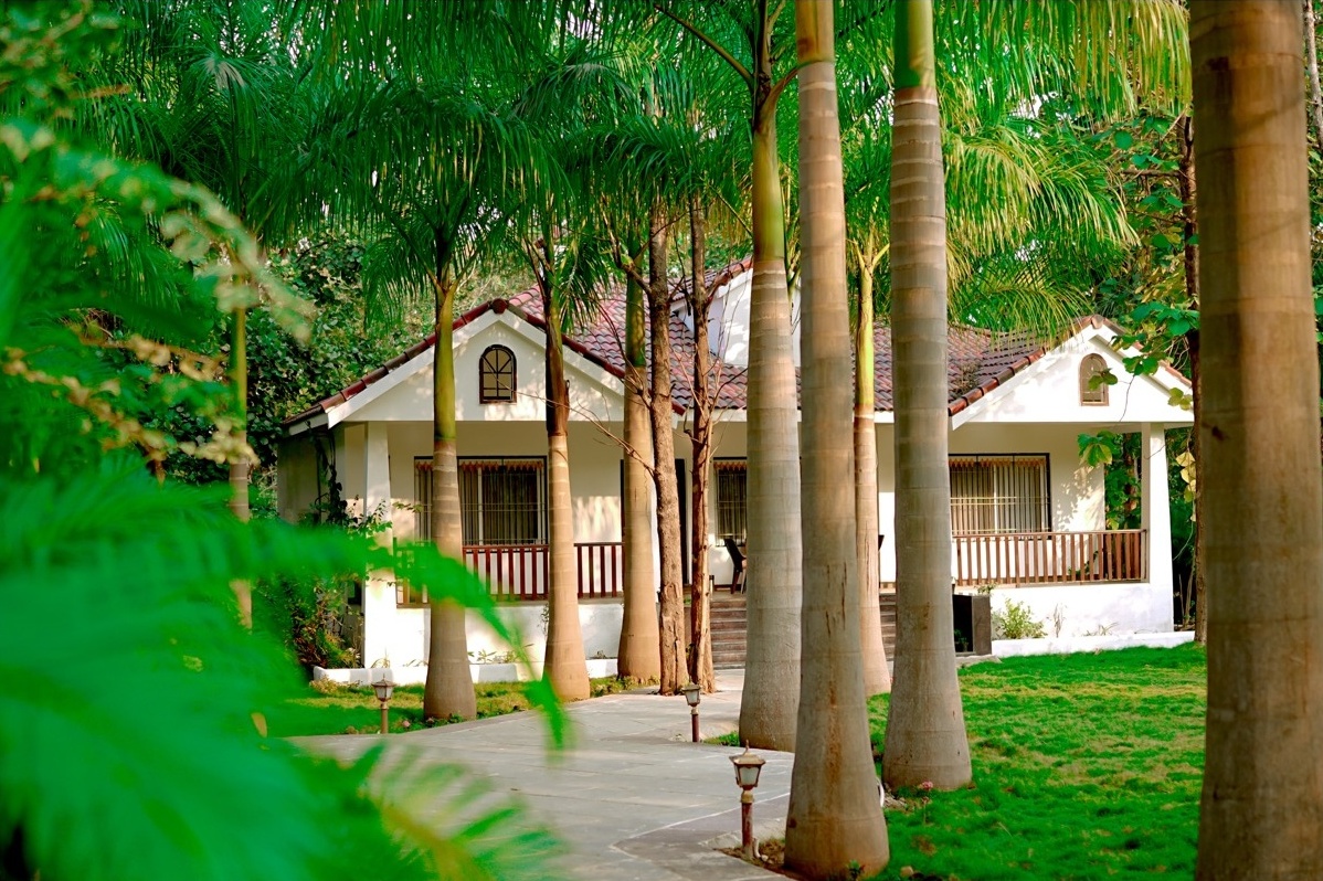 Rosewood Villas Pench hero view of villas, swimming pool, and surrounding forest.