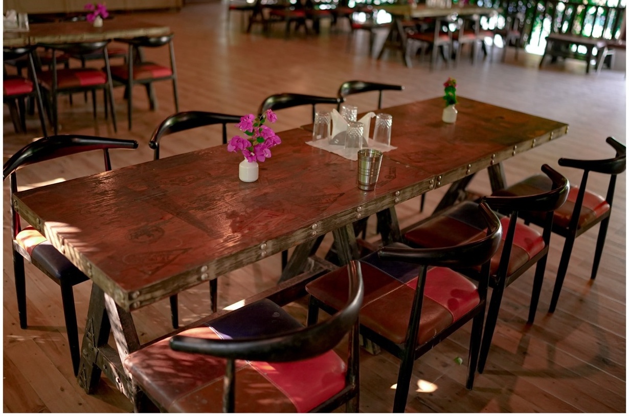 Rosewood Villas Pench rustic dining table with flower centerpiece in restaurant.
