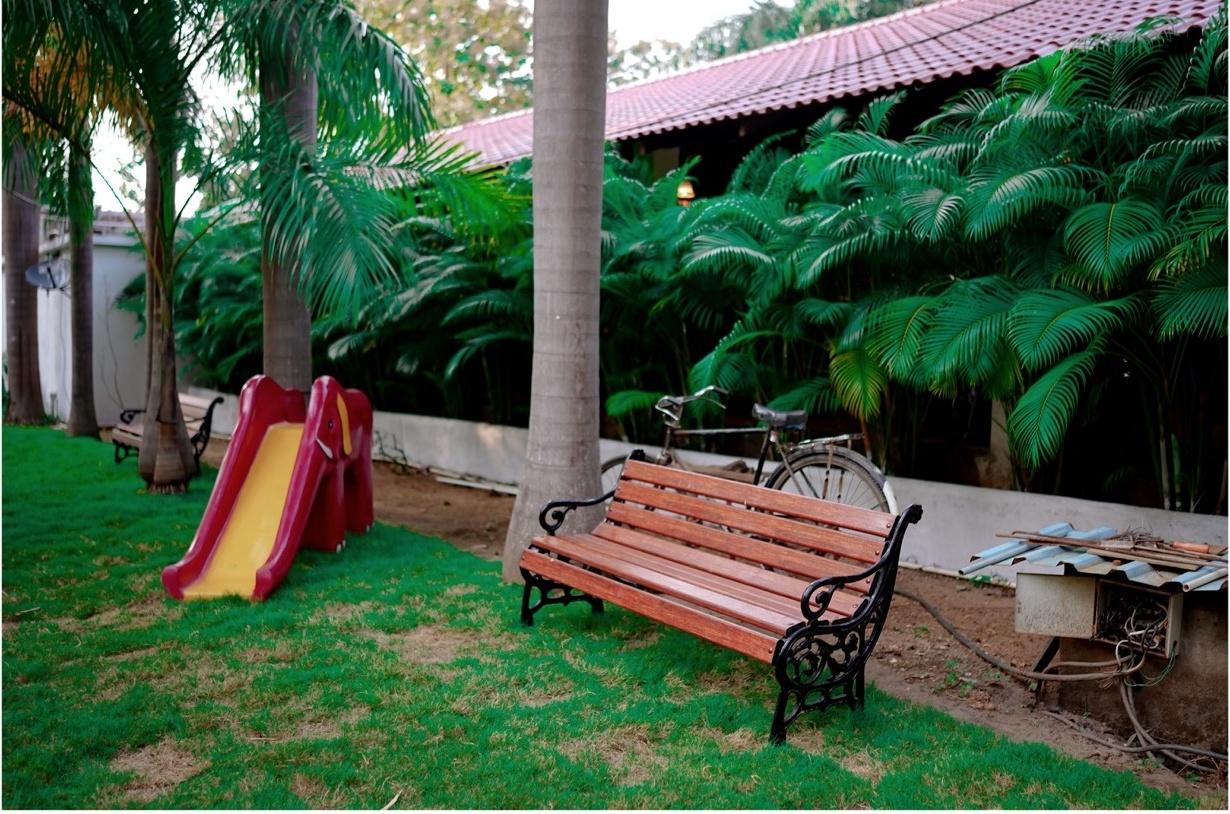 Rosewood Villas Pench villa entrance with garden pathway, plants, and cottage façade creating a village feel.