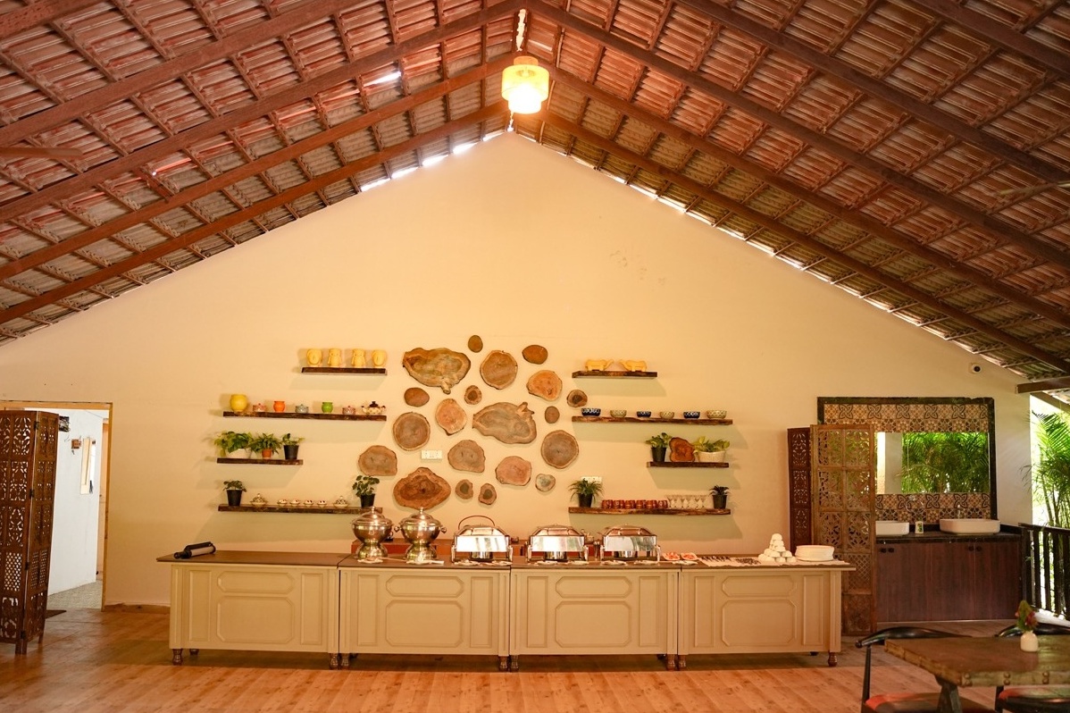 Rosewood Villas Pench rustic buffet dining hall interior with warm lighting and wooden details.