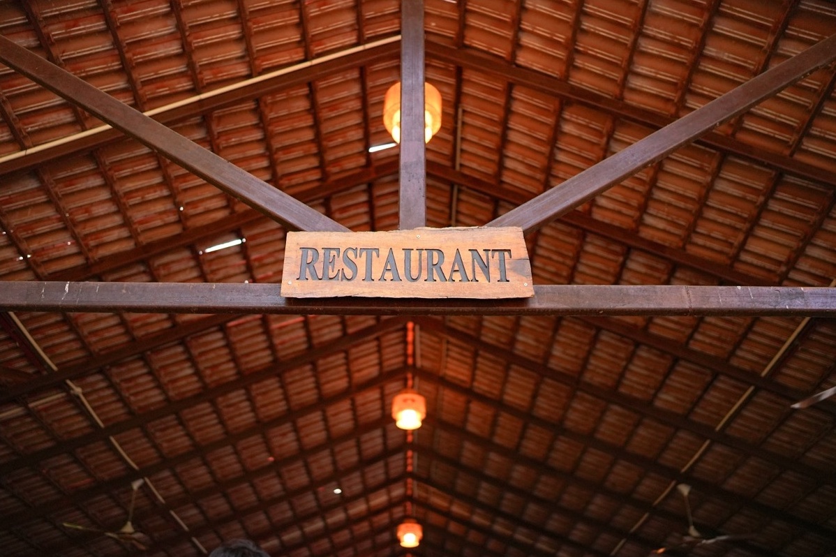 Rosewood Villas Pench rustic restaurant signboard at resort dining entrance.
