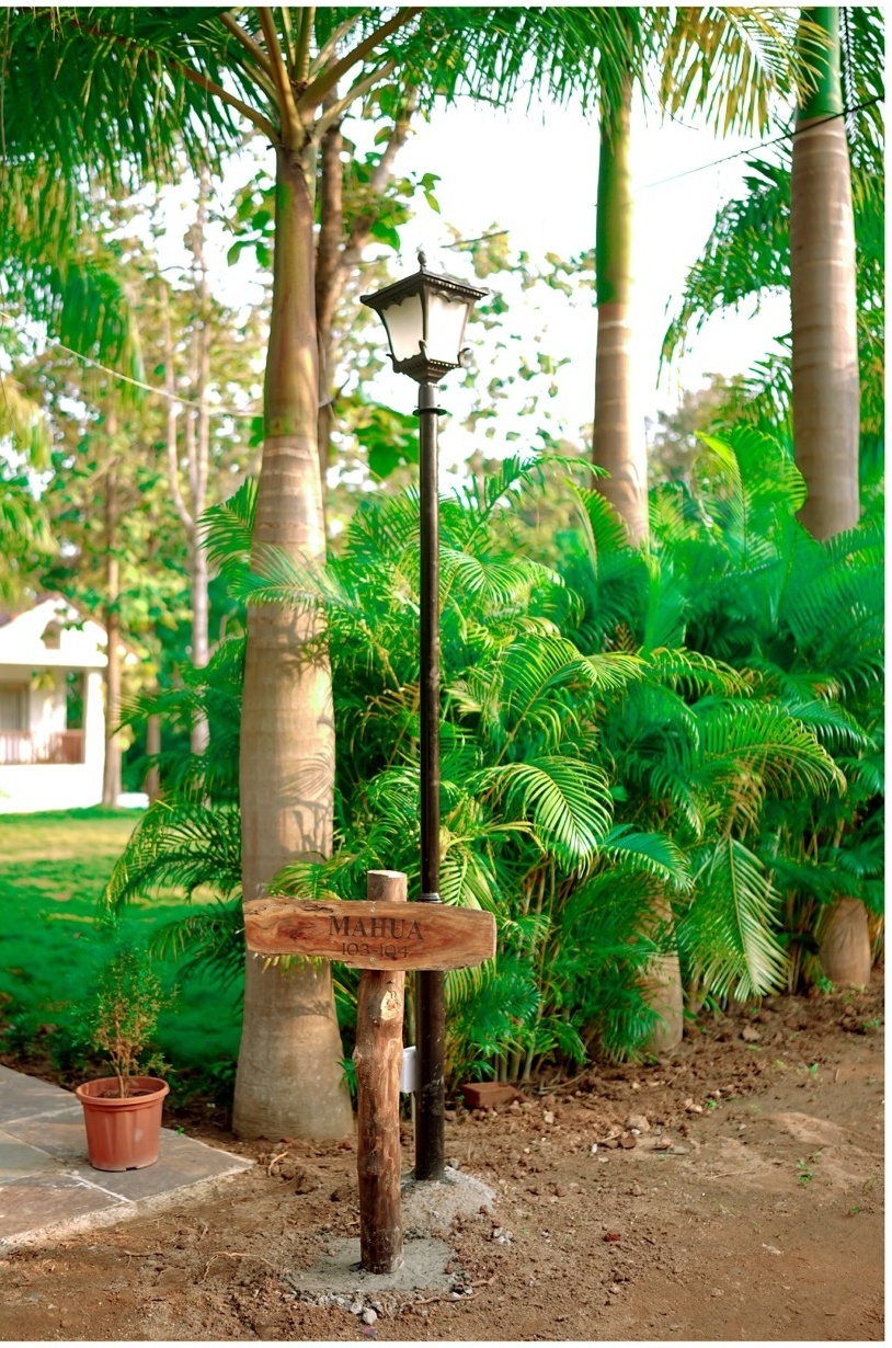 Rosewood Villas Pench directional sign showing way to Mahua villa along garden path.